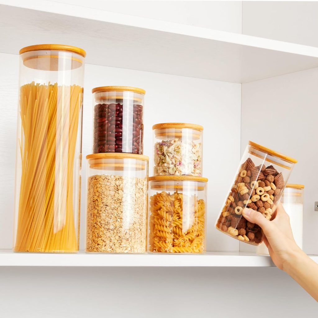 different sizes of glass jars filled with pasta, beans, oats, and cereal